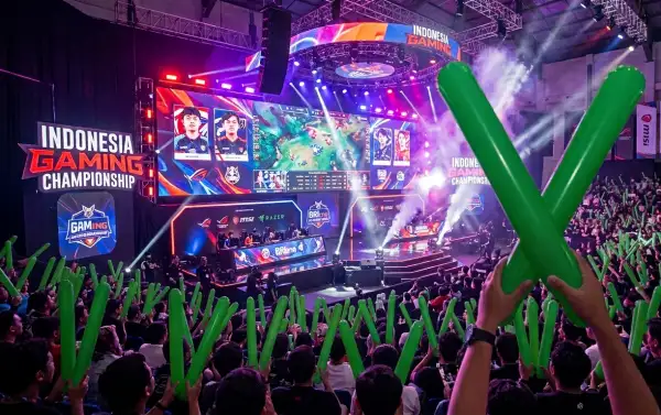 Penonton membawa balon tepuk hijau saat menyaksikan turnamen esports Indonesia Gaming Championship.