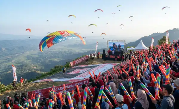 Peserta festival paralayang memberikan semangat di area pertunjukan.