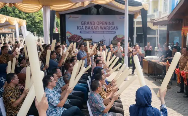 Peserta acara peresmian rumah makan menggunakan balon tepuk sebagai hiburan bersama.