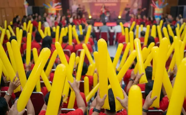 Penonton mengikuti acara hiburan di dalam gedung.