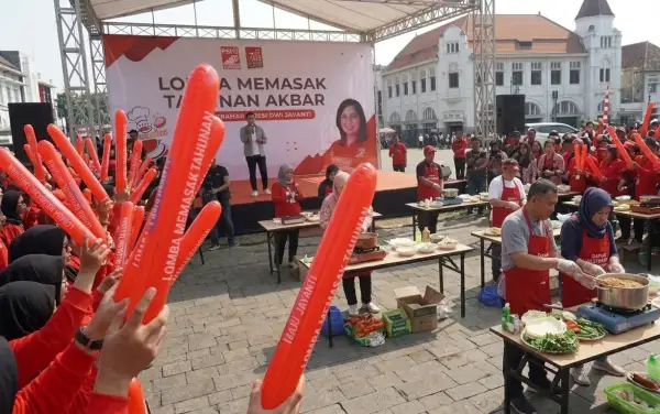Kemeriahan penonton membawa balon tepuk merah pada ajang lomba memasak akbar