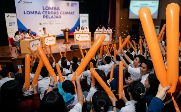 Balon tepuk bengkalis berwarna oranye diangkat peserta saat mendukung lomba cerdas cermat pelajar di dalam gedung.