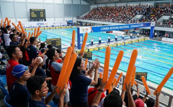 Balon tepuk Blora digunakan penonton untuk menyemangati peserta lomba renang di dalam gedung olahraga.