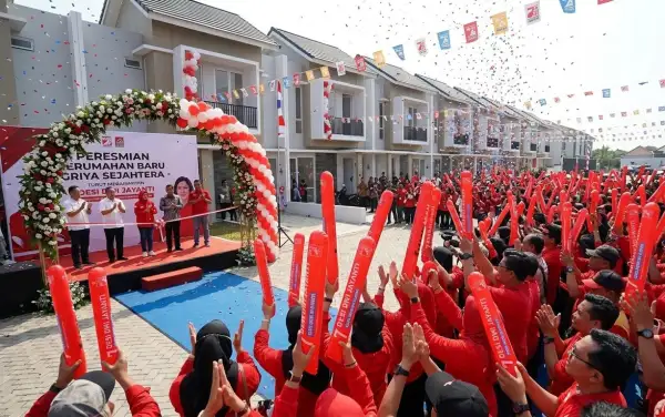 Warga memeriahkan acara peresmian perumahan dengan menggunakan balon tepuk merah