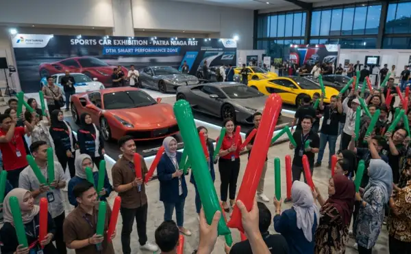 Penonton membawa balon tepuk warna merah dan hijau saat menikmati pameran mobil sport.