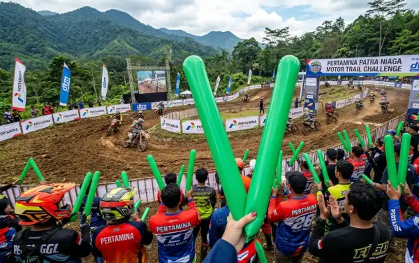 Balon tepuk Bukittinggi berwarna hijau digunakan penonton untuk menyemangati peserta dalam ajang motor trail di area pegunungan.