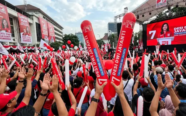Penonton mengangkat balon tepuk Bukittinggi merah dan putih saat mengikuti acara kampanye yang berlangsung di area perkotaan.
