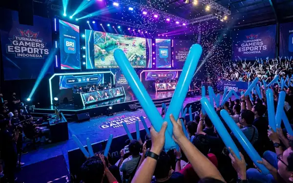 Penonton menyaksikan pertandingan turnamen gamers esports di dalam arena.