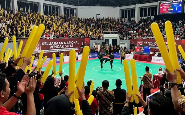 Suporter menyemarakkan kejuaraan pencak silat nasional di dalam arena pertandingan.