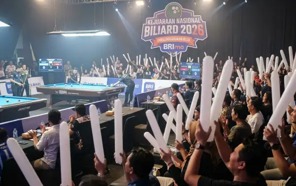 Penonton mengangkat balon tepuk putih saat menyaksikan pertandingan pada kejuaraan nasional biliard.