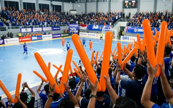 Pertandingan futsal Suporter mengangkat balon tepuk Indragiri Hilir berwarna oranye untuk menyemarakkan pertandingan futsal di dalam arena olahraga