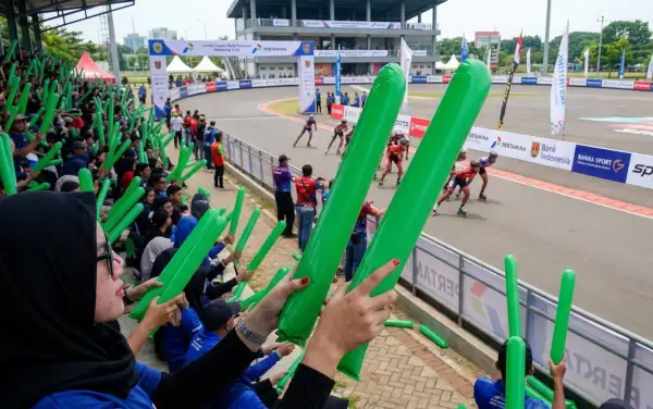 Balon tepuk Kampar hijau digunakan oleh suporter untuk mendukung atlet dalam perlombaan sepatu roda di arena balap.