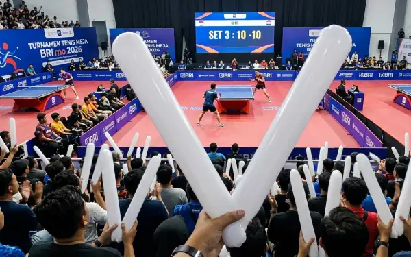 Balon tepuk karo berwarna putih digunakan penonton saat menyaksikan pertandingan tenis meja