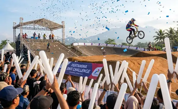 Suasana penonton memeriahkan lomba sepeda BMX dengan mengangkat balon tepuk berwarna putih untuk memberikan semangat kepada peserta.