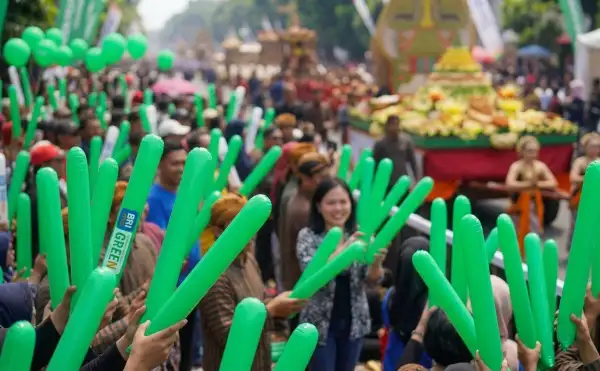 Kerumunan masyarakat membawa menyaksikan festival gunungan di tengah suasana yang ramai.