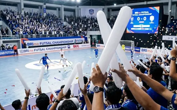 Suporter memberikan dukungan pada pertandingan futsal menggunakan balon tepuk putih.