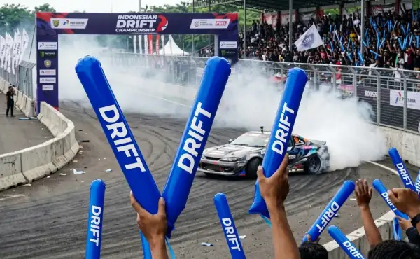 Balon tepuk Kuantan Singingi berwarna biru digunakan penonton saat menyaksikan aksi mobil drift di lintasan.