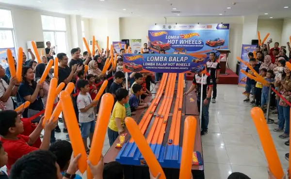 Penonton sedang menyaksikan perlombaan Hot Wheels di dalam ruangan.