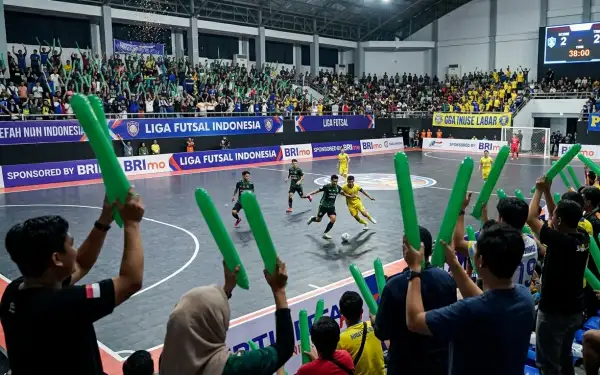 Suporter sedang menyaksikan pertandingan futsal di gor futsal