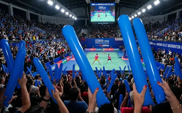 Ribuan penonton menyemangati para atlet dalam pertandingan badminton.