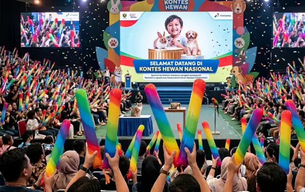 Penonton kontes hewan mengangkat balon tepuk warna-warni saat mengikuti acara di dalam gedung.