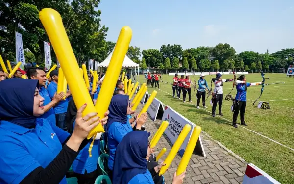 Sebagai suporter memberikan penyemangat peserta lomba panahan di lapangan terbuka.