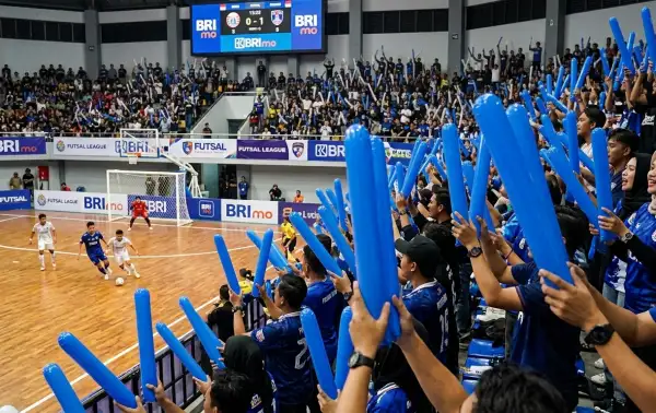 Balon tepuk pamasan digunakan penonton untuk memberikan dukungan dalam pertandingan futsal di arena olahraga