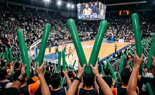 Suporter memenuhi tribun sambil mengibarkan balon tepuk Pariaman hijau pada pertandingan basket yang berlangsung meriah.