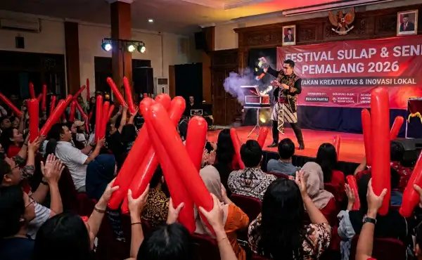 Penonton menggunakan balon tepuk merah saat menyaksikan pertunjukan sulap di Pemalang
