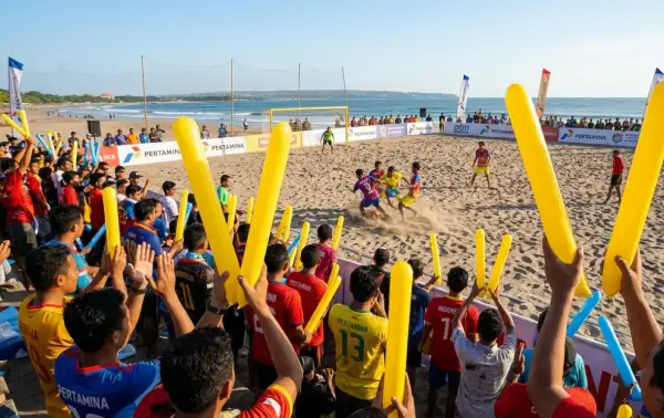 Balon tepuk Pematangsiantar digunakan penonton untuk menyemangati pertandingan sepak bola pantai di tepi laut.