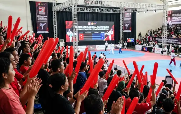Suporter memberikan dukungan pada pertandingan taekwondo.