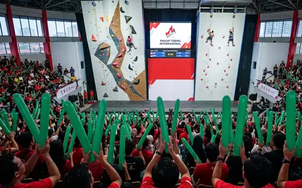 Penonton menggunakan balon tepuk saat pertandingan panjat tebing