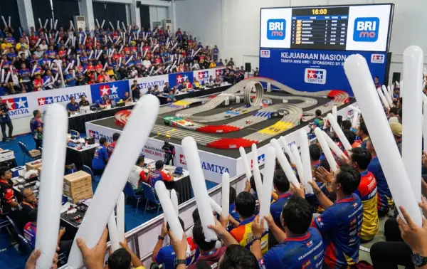 Balon tepuk pesisir pantai digunakan penonton untuk memberikan semangat saat perlombaan mobil Tamiya berlangsung.