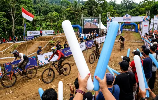 Penonton menyaksikan perlombaan sepeda gunung di lintasan.