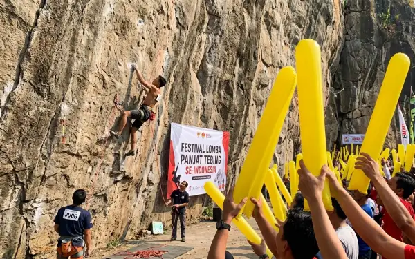 Suporter mendukung peserta dalam festival lomba panjat tebing.