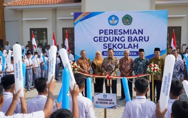 siswa membawa balon tepuk berwarna putih dan biru saat peresmian gedung baru sekolah.