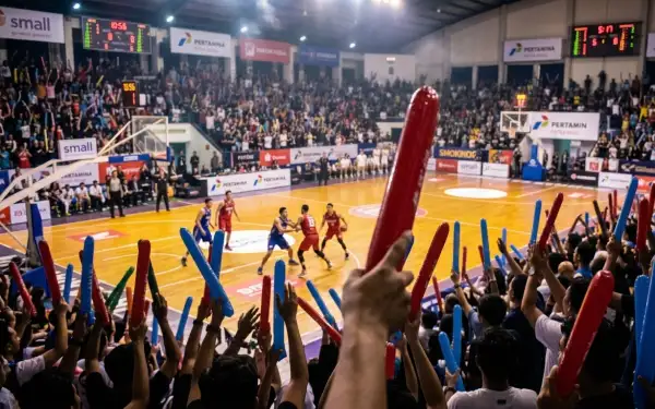 Penonton menggunakan balon tepuk Surakarta untuk mendukung pertandingan basket di dalam gedung olahraga