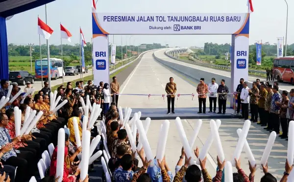Peserta peresmian jalan tol mengangkat balon tepuk putih saat mengikuti acara pembukaan jalan baru.