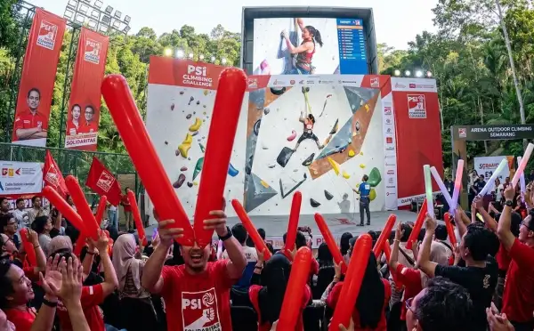 Balon tepuk Toba Samosir berwarna merah digunakan penonton untuk memeriahkan perlombaan panjat tebing.