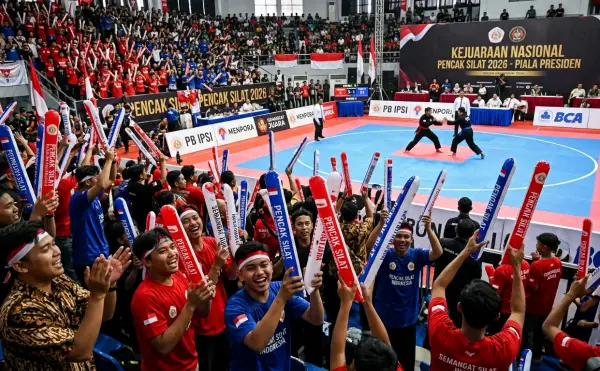 Suporter membawa balon tepuk merah putih untuk menyemarakkan kejuaraan nasional pencak silat di arena pertandingan.