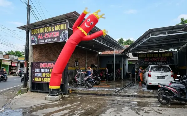 Balon sky dancer Jambi di depan tempat cuci motor dan mobil untuk menarik perhatian pelanggan.