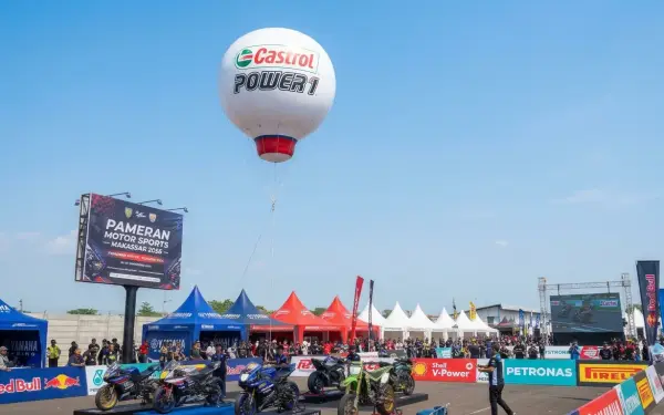 Balon udara Makassar bermerek Castrol sebagai media promosi pada pameran motor sport dengan deretan motor dan stan sponsor.